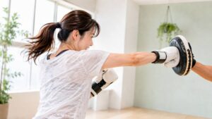 ミットにパンチを打つ女性（パーソナルジム卒業後の運動）