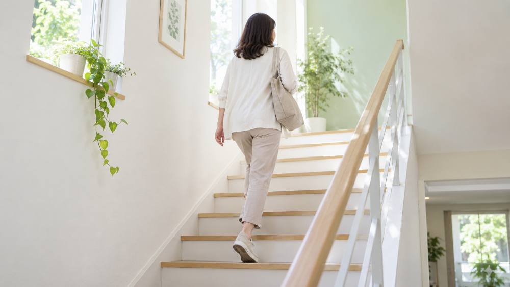 階段を軽やかに上る40代後半の女性